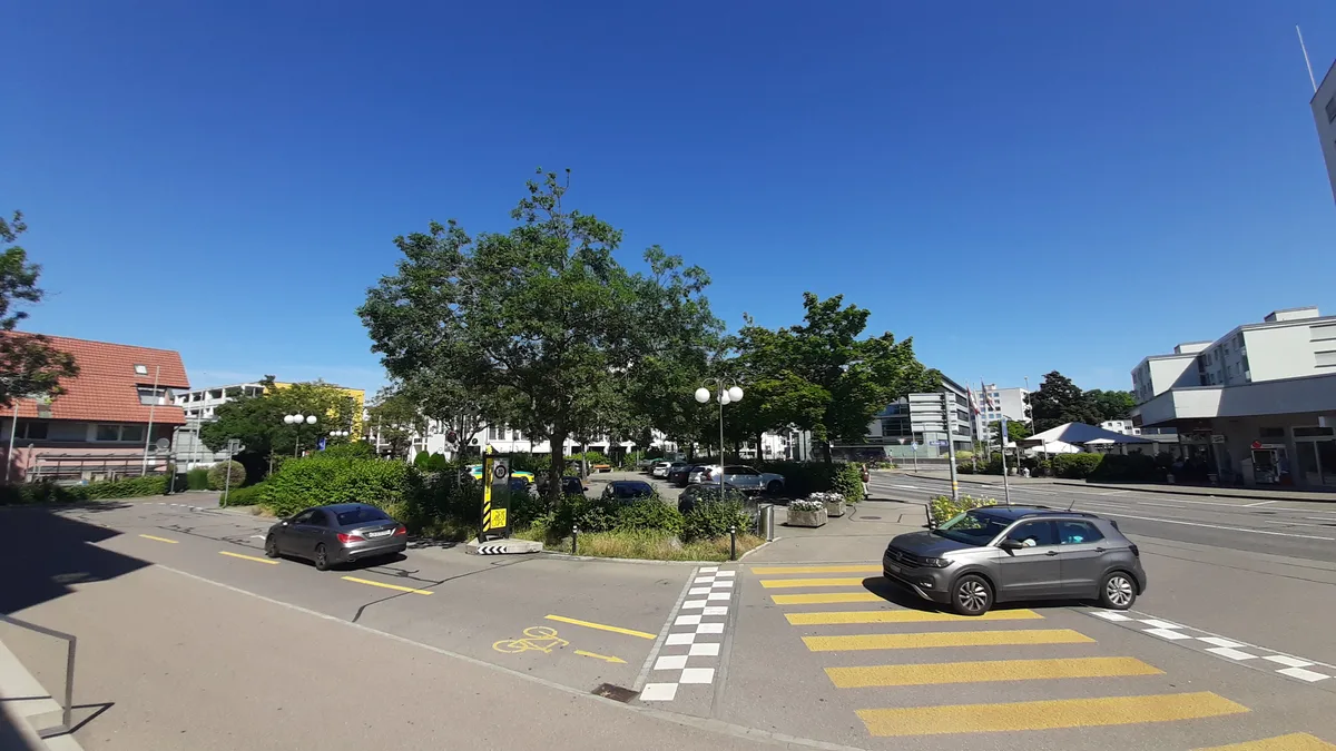 Seit Jahren ein politischer Zankapfel: der Adlerplatz im Zentrum Dübendorfs. (Archiv) Ein Parkplatz mit Autos und Bäumen im Zentrum einer Agglomerationsstadt.